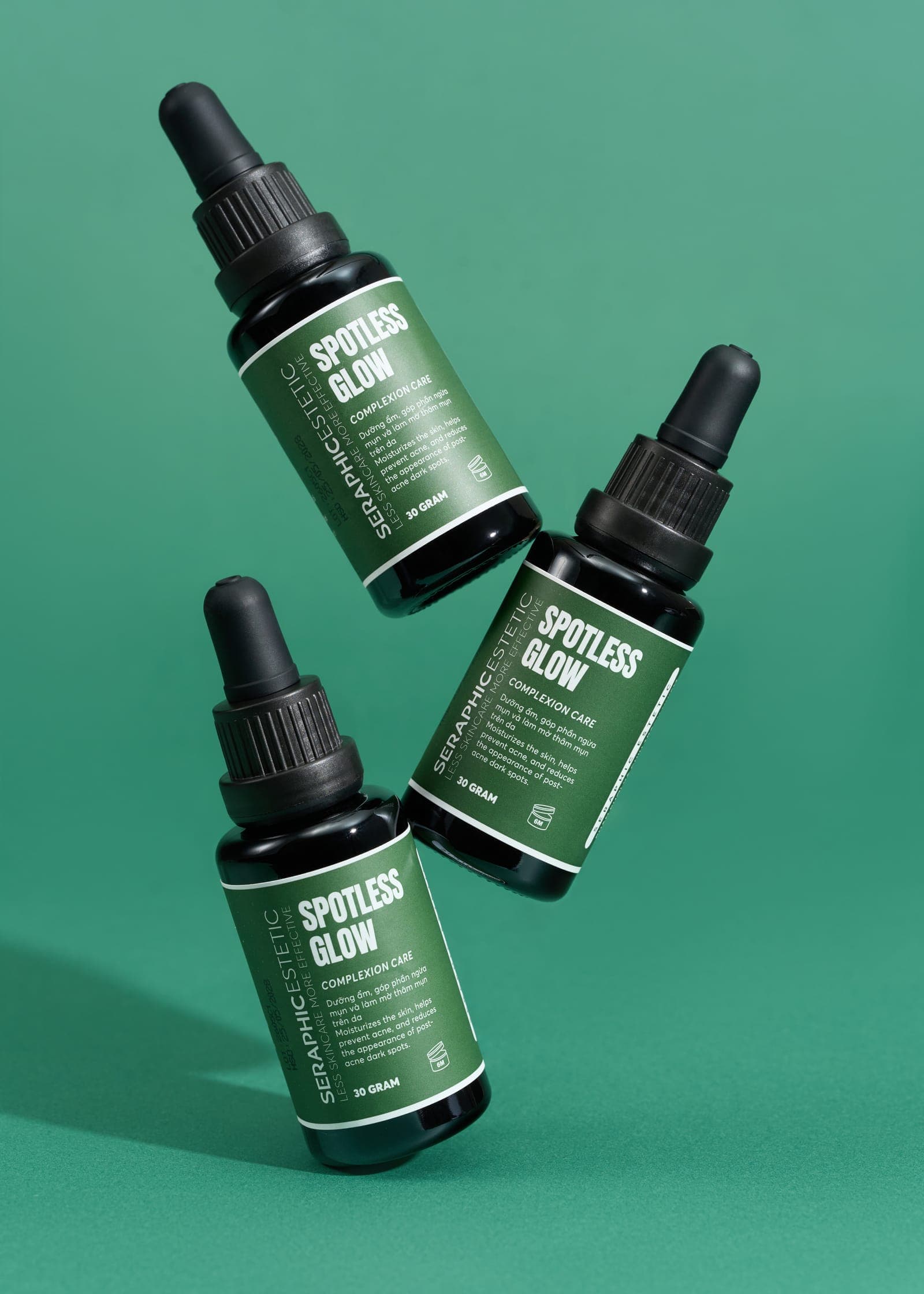 Ba chai serum Spotless Glow trên nền xanh